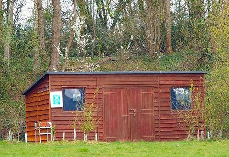 Foxes Den camping area with wooden shelter and altar fire